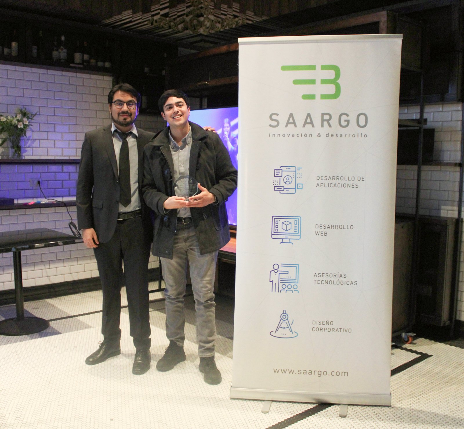 Equipo Saargo recibiendo un reconocimiento junto al banner corporativo